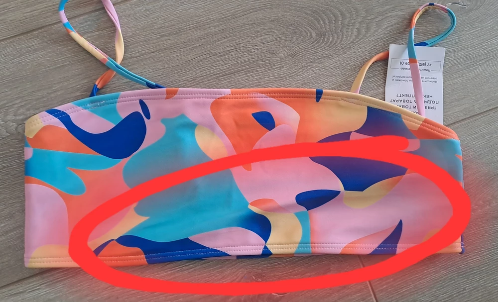 Посредственный, восторги не понятны. Быстро же после ухода брендов мы забыли, что такое нормальные лекала, нормальные ткани... по сути две звезды от меня - одна за расцветку, другая за идею с юбкой. А теперь смотрим. 
Лиф - ткань наружная пристрочена к подкладу неровно, пузырит с обеих сторон, я обвела. Как ни выравнивай. 
Но вообще убила юбка, я не знаю, кто этих бедняг подвальных учил шить. Почему перед длиннее зада? На фото юбка задней стороной кверху. Зачем эти лишние см на пузе? В юбках всегда чуть короче перед, это азы, блин. Ну и небольшие коцки по всей ткани и несоответствие верха-низа по размерам (трусы малы), как тут уже писали - в качестве бонуса:) 
Взяла, потому что очень уж настроена была взять, но радости от покупки конечно никакой...