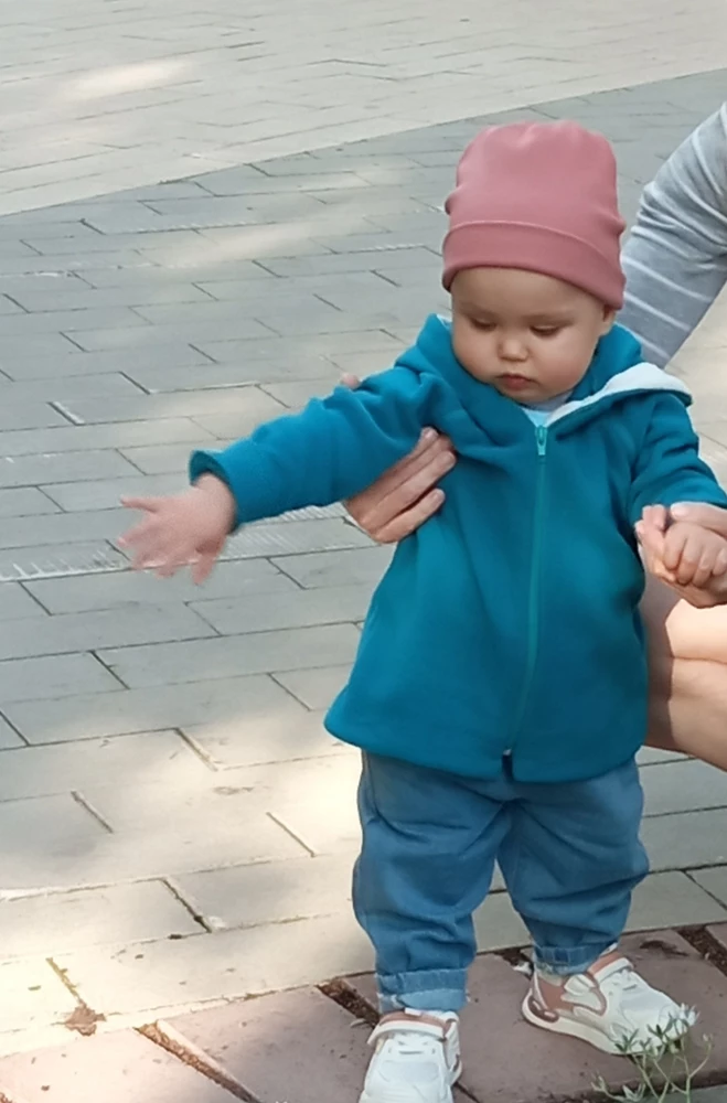 Материал синтетика, но мягкий, приятный после стирки, на рост малыша 78 см взяла размер 86 навырост, манжеты на рукавах загнули, швы аккуратные, смотрится как так и надо)) Капюшон удобный